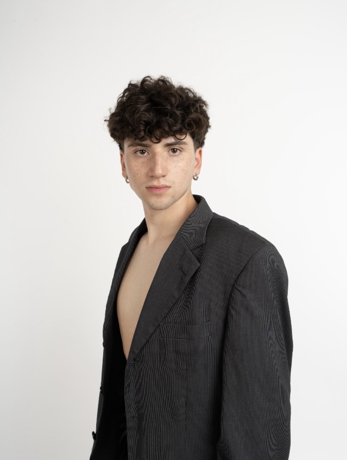 Martín Calvo con blazer gris, retrato frontal en estudio sobre fondo blanco