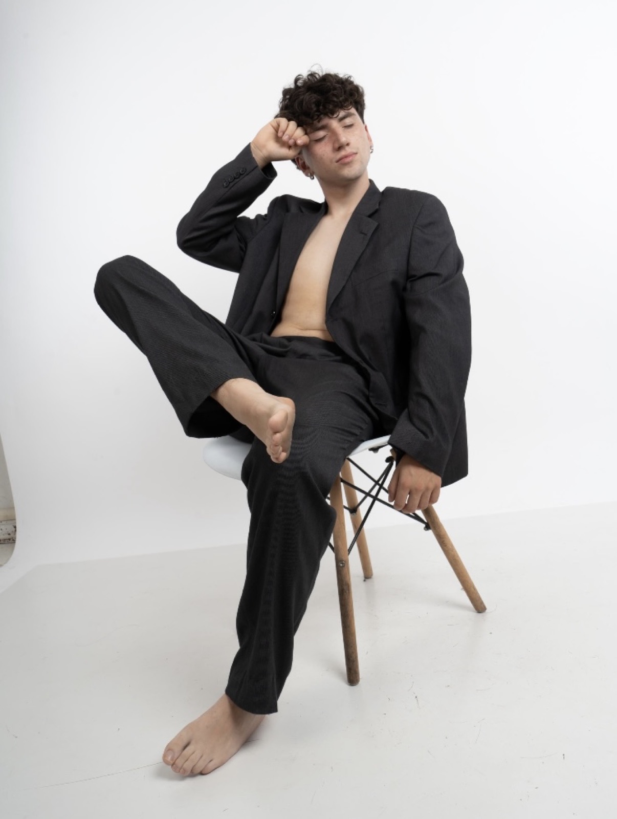 Martín Calvo sentado, con traje oscuro, en una pose dramática y expresiva